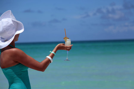 Woman with Pina Colada cocktail relaxin on the Caribbean Sea