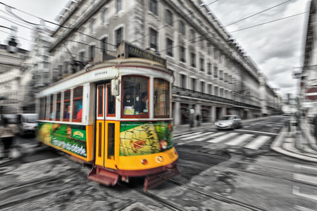 View of the traditional yellow Tram 28 passing through the streets of Lisbon, Portugal providing innercity public transportのeditorial素材