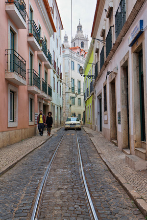 Street scene in Lisbon city centre with a deserted street running between multistorey historical buildings with decorative balconies and shops at ground levelのeditorial素材