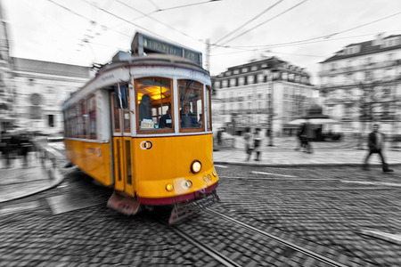 View of the traditional yellow Tram 28 passing through the streets of Lisbon, Portugal providing innercity public transportのeditorial素材