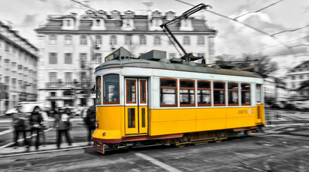 View of the traditional yellow Tram 28 passing through the streets of Lisbon, Portugal providing innercity public transportのeditorial素材