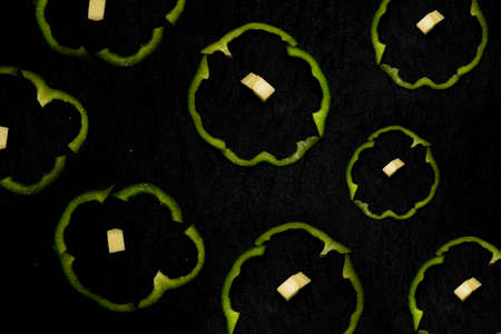 cutting green peppers in round shape and cheese cube.の写真素材