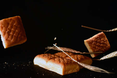 wheat and bread pieces on black background.の写真素材