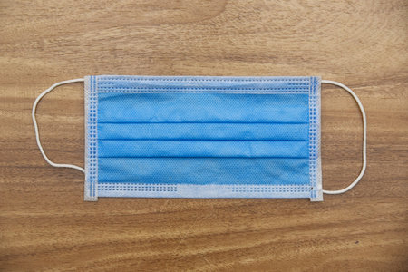 Medical blue face mask with wooden background.の写真素材
