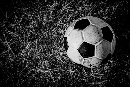 BW old dirty ball on grassの写真素材