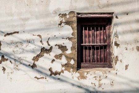 Aged wall with old red windowの写真素材
