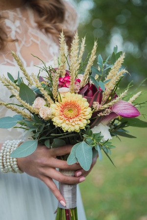 Beautiful wedding bouquet in hands of the brideの写真素材