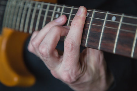 Practicing in playing guitar. Handsome young men playing guitar