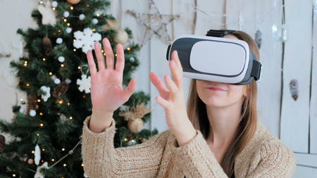 Woman using virtual reality glasses. Virtual reality mask. VR. Christmas, future and technology conceptの写真素材