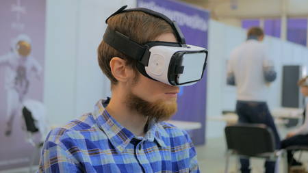 Virtual reality game. Young man using virtual reality glasses. VRの写真素材