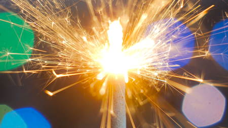 Firework sparkler burning. Elegant abstract garlands bokeh background. Extreme macro shot. Christmas and New Year conceptの写真素材