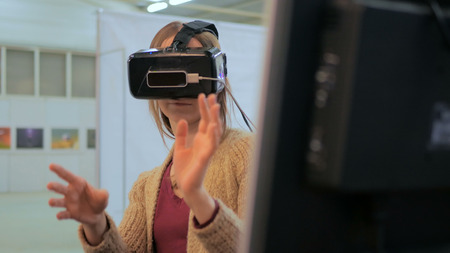 Virtual reality game. Young woman using virtual reality glasses. VRの写真素材