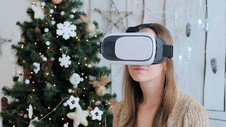 Woman using virtual reality glasses. Virtual reality mask. VR. Christmas, future and technology conceptの写真素材