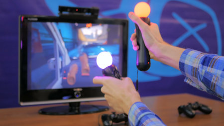 Virtual reality game. Young man using virtual reality glasses and hand controlers
