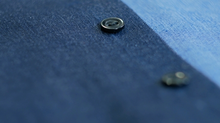 Close up view of smart business women's suit jacket - denim, texture, buttons. Selective focus with shallow depth of fieldの写真素材