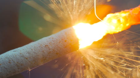 Firework sparkler burning. Elegant abstract garlands bokeh background. Extreme macro shot. Christmas and New Year conceptの写真素材