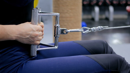 Close up shot. Athletic young woman working out on a fitness exercise equipment at the gym. Health,...
