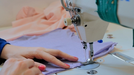 Professional tailor, fashion designer sewing clothes with sewing machine at atelier. Fashion and tailoring conceptの写真素材