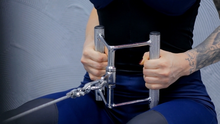 Close up shot. Athletic young woman working out on a fitness exercise equipment at the gym. Health, sport and workout conceptの写真素材