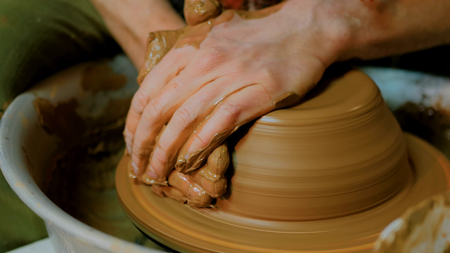 Professional male potter making bowl in pottery workshop, studio. Handmade, art and handicraft conceptの写真素材