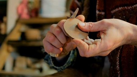 Professional male potter working in workshop, studio - making cap for kettle. Close up shot of potters hands. Handmade, small business, crafting work conceptの写真素材