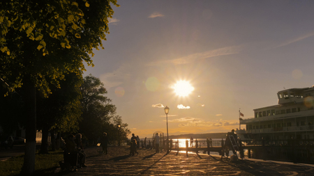 Unrecognizable people silhouettes walking on quay of old russian town Plyos. Sunset light, golden hour. Travelling conceptの写真素材