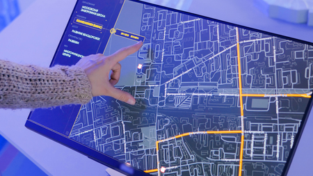 MOSCOW, RUSSIA - SEPTEMBER 10, 2017: Smart City Exhibition. Woman using interactive touchscreen display with virtual map of Moscow at modern technology showのeditorial素材