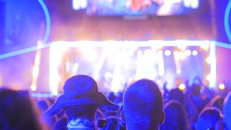People silhouette partying at night open air concert in front of the stage. Nightlife and entertainment conceptの写真素材
