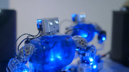 Humanoid robots with colourful illumination dancing at technology exhibition. Future and robotic...