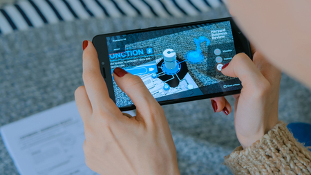 MOSCOW, RUSSIA - AUGUST 10, 2018. Woman using smartphone with augmented reality app - virtual robotized production module. Future, production, industrial and technology conceptのeditorial素材