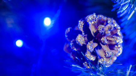 Christmas tree pinecone decoration with blue illumination. Holiday, celebration and new year conceptの写真素材