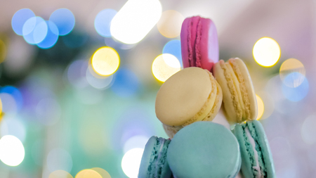 Macaron tower - multicolored tasty french macaroons with Christmas bokeh garland light. French cuisine, candy, holiday, new year and food conceptの写真素材