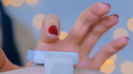 Woman using smart watch at home. Warm bokeh light background. Entertainment and technology concept. Close up shot of woman hand with smartwatchの写真素材