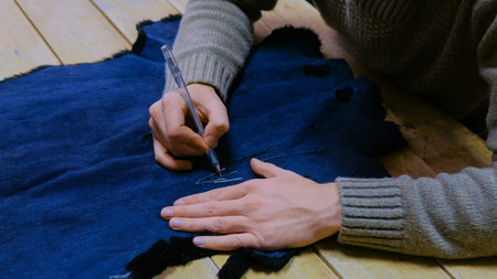 Professional male skinner, furrier working with beaver fur skin at atelier, workshop. Fashion and...