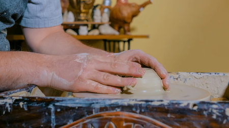 Professional male potter shaping mug in pottery workshop, studio. Crafting, artwork and handmade...