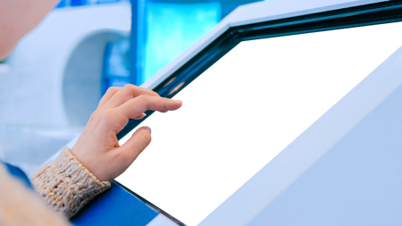 Woman using interactive digital informational kiosk with touchscreen display at urban exhibition - scrolling and touching. Education, mock-up, template and technology conceptの写真素材