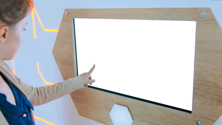 Woman using interactive touchscreen kiosk with white empty screen at modern history museum - scrolling and touching. Education, mock-up, template and technology conceptの写真素材