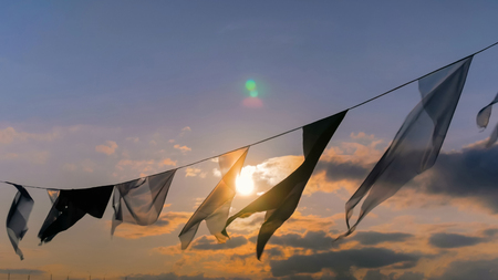 Decorative garland of satin flags silhouette waving in the wind at city street holiday, festival or carnival. City festival conceptの写真素材