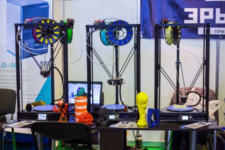 MOSCOW, RUSSIA - OCTOBER 12, 2018: 3D Print Expo - automatic 3D printers in row working at modern technology exhibition. 3D printing, additive technologies and futuristic conceptのeditorial素材