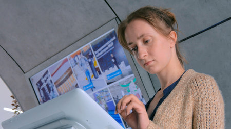 Woman using interactive touchscreen display at urban exhibition - scrolling and touching. Education...