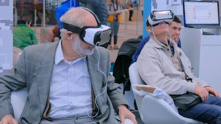 MOSCOW, RUSSIA - July 30, 2018: Moscow Urban Forum. Senior people using virtual reality headset at exhibition, show. VR cinema conceptのeditorial素材