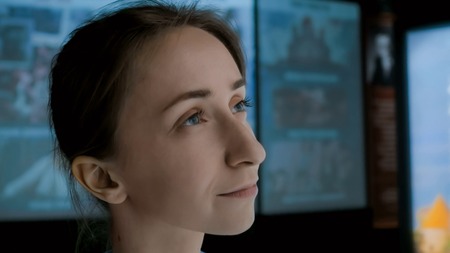 Young woman looking around in modern historical museum. Evening time, low light. Education, learning and entertainment conceptの写真素材