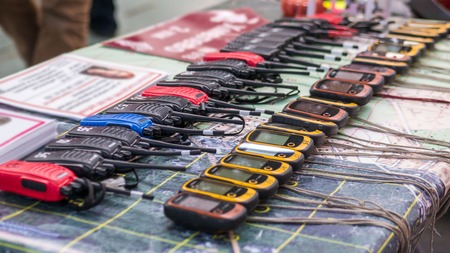 Portable emergency walkie talkie and navigators in a row at emergency services show. Equipment of search rescue teamの写真素材
