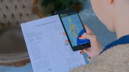 MOSCOW, RUSSIA - AUGUST 10, 2018. Woman using smartphone with augmented reality app - educational anatomy human body system. Future, medical and technology conceptのeditorial素材