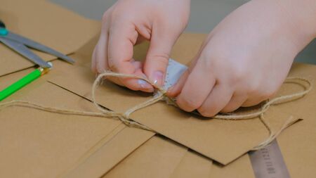 Professional woman decorator, designer working with kraft paper and wrapping envelope at workshop, studio. Decorating, handmade and art conceptの写真素材