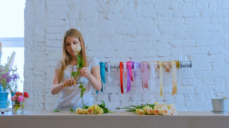 Professional floral artist, florist cutting flowers at flower shop, workshop. Floristry, handmade...