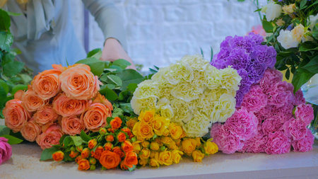 Professional floral artist, florist sorting colorful flowers for bouquet at workshop, flower shop. Floristry, handmade and small business conceptの写真素材