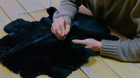 Professional male skinner, furrier working with beaver fur skin at atelier, workshop. Fashion and...