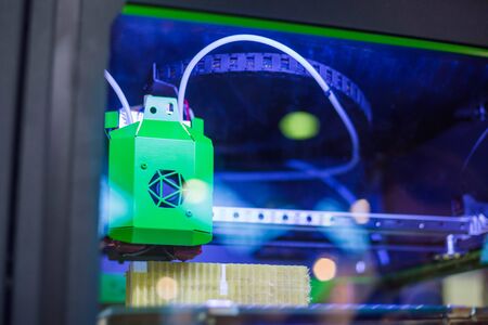 Print head of 3D printer machine printing plastic model at modern scifi technology exhibition. 3D printing, additive technologies, 4.0 industrial revolution and futuristic conceptの写真素材