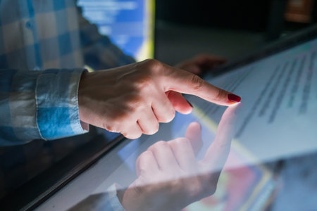 Education, entertainment, learning and technology concept - woman using interactive touchscreen display of electronic kiosk at modern museum or exhibitionの写真素材
